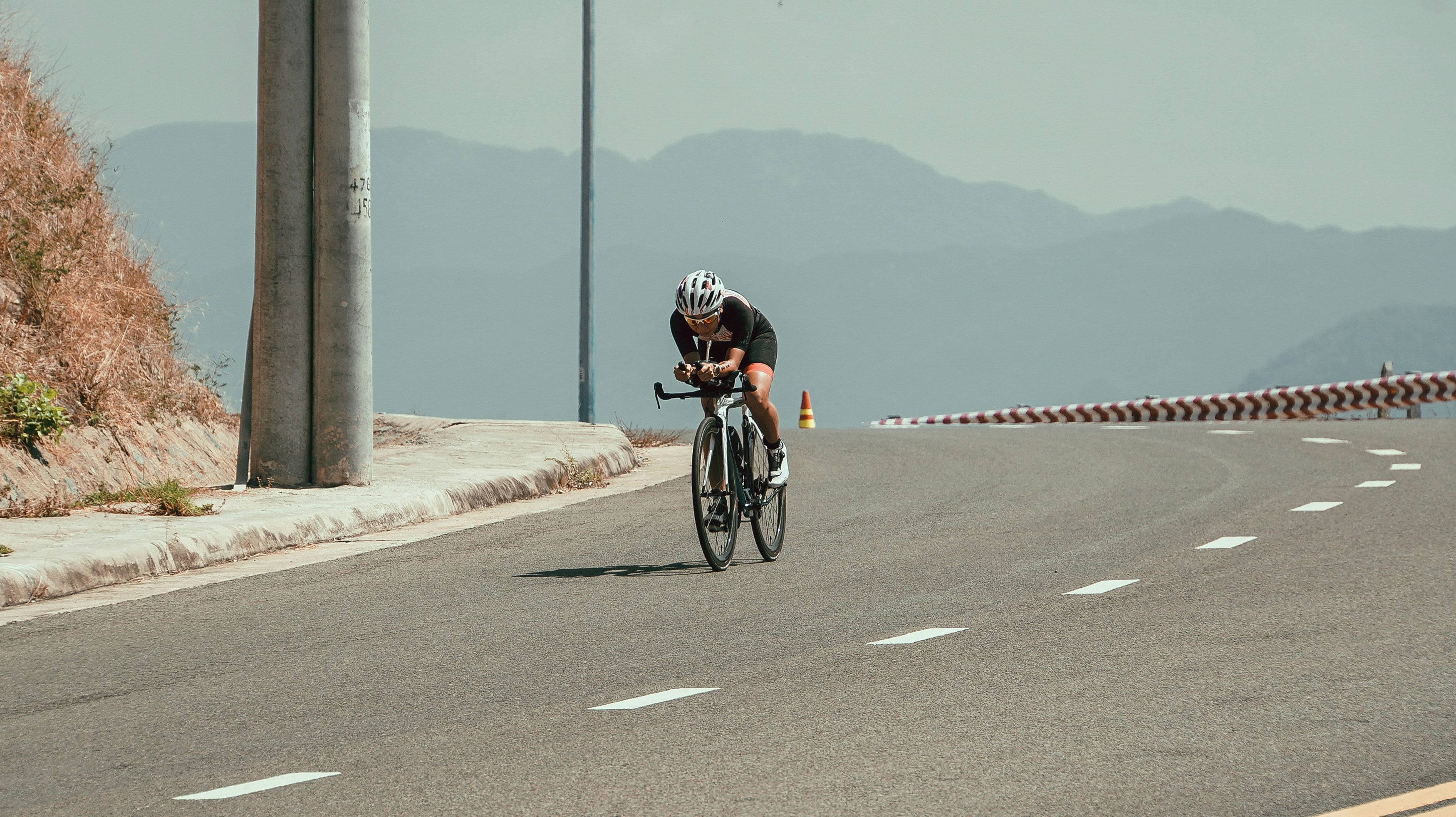 Ciclista en carretera con hidratación de electrolitos deportivos